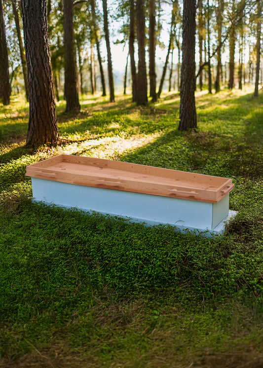 Opbaarplank Gentle Tenderness van naaldhout met geïntegreerde grepen, geplaatst in een serene bosomgeving met zonlicht tussen de bomen