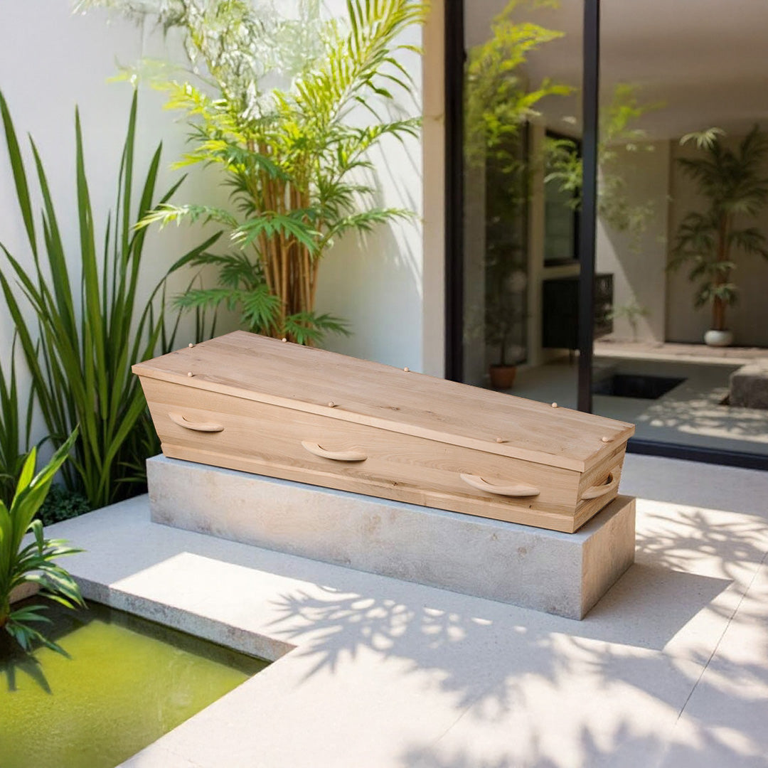Uitvaartkist Opal’s Touch van wild eikenhout met katoenen interieur, geplaatst in een serene moderne patio met groen en daglicht