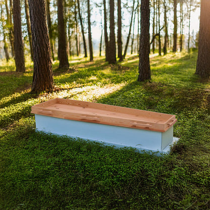 Opbaarplank Gentle Tenderness van naaldhout met geïntegreerde grepen, geplaatst in een serene bosomgeving met zonlicht tussen de bomen