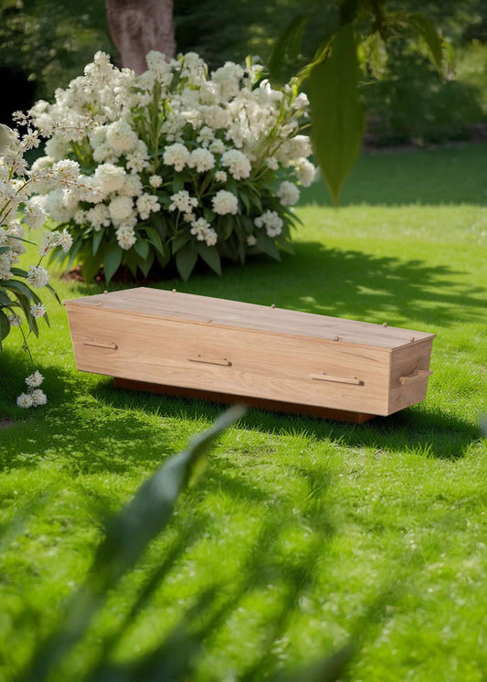 Uitvaartkist LinaLite® True Embrace van licht eikenhout, slechts 17 kg, en 50% minder hout, fijn geschuurd en puur, geplaatst in een serene natuurlijke setting