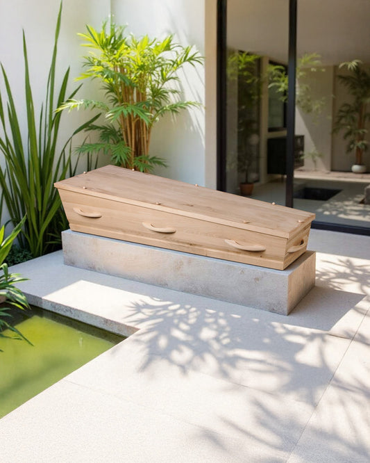 Uitvaartkist Opal’s Touch van wild eikenhout met katoenen interieur, geplaatst in een serene moderne patio met groen en daglicht
